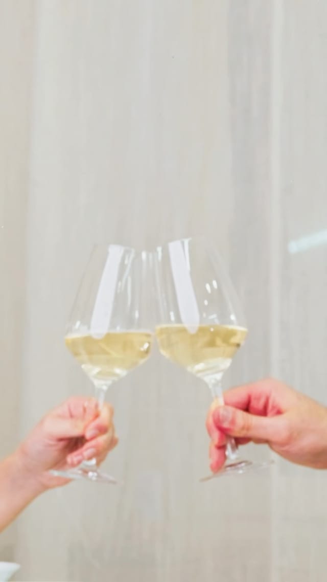 Un brindisi con due calici di vino bianco.